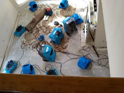 Air movers drying a wood floor after a water loss in Arlington, TX